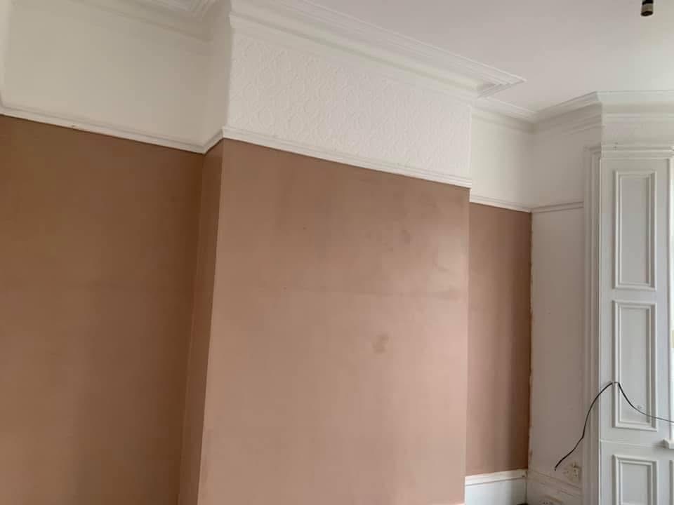 A Victorian room with lower walls freshly re-plastered beneath an ornate cornice
