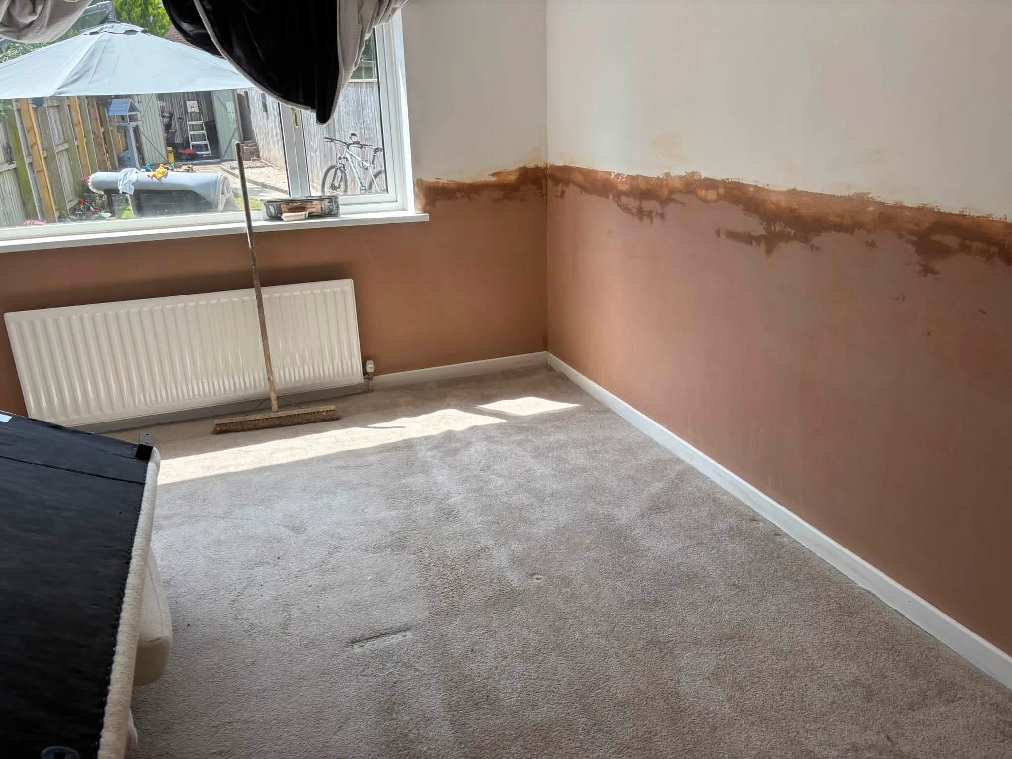 A bedroom with fresh plaster along the lower walls, blended into the paint above